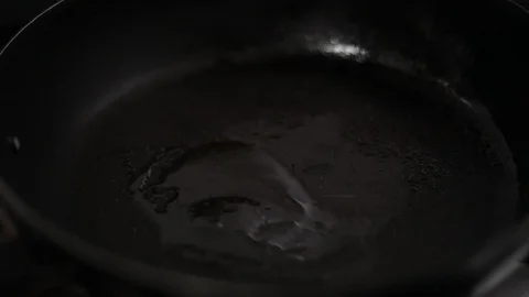 Adding Olive Oil on Black Pan Stock Footage 129327279