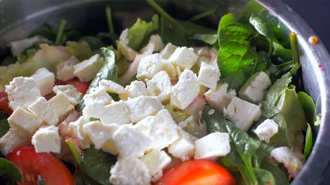 Adding olive oil to a mix of salads. Slow motion Stock Footage 108147581