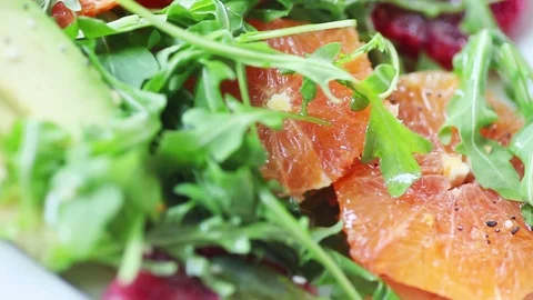 Adding olive oil vinaigrette to orange salad Stock Footage 104810599