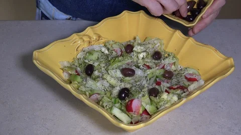 Adding olives on top of vegetable salad Stock Footage 106648249