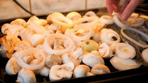 Adding onion rings on a grill with fish and mushrooms Stock Footage 85740657