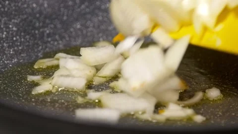 Adding onions into skillet with hot olive oil Stock Footage 141992513