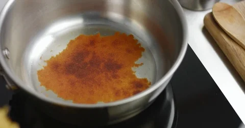 Adding paprika to hot oil in pan Stock Footage 81616034
