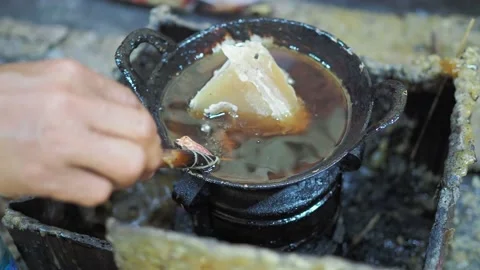 Adding paraffin wax or malam on pan stove as preparation batik painting process Stock Footage 143751266
