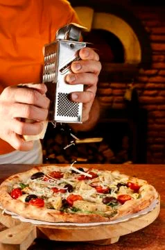 Adding parmesan cheese To Pizza Stock Photos