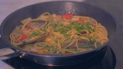 Adding parsley to a pan with seafood and mussels Stock Footage 111671028