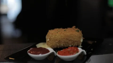 Adding Parsley on Top Of Breaded Brie Cheese with Sauces (Pepper and Ketchup) Stock Footage 129327443