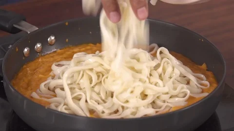 Adding Pasta and other ingredients  to red Bell Pepper Sauce Vídeos de archivo 79061171