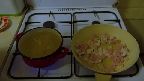 Adding Pasta to Boiling Pot While Meat Cooks on Stove Stock Footage 341767155