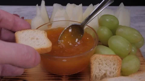 Adding peach jam to bread toast with spoon 4k Stock Footage 150601317