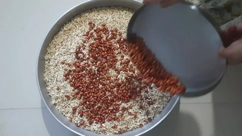 Adding Peanuts to Puffed Rice Mixture for Traditional Indian Chiwda Preparation 스톡 동영상 334927114