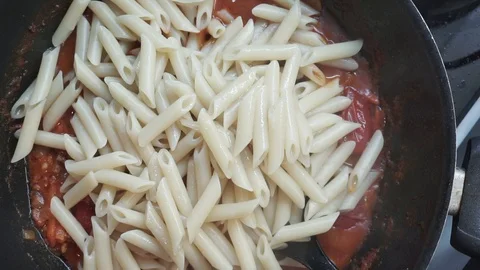 Adding penne pasta Stock Footage 97410828