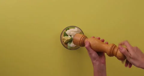 Adding pepper to chickpeas, avocados, tahini lime juice, and salt 1 Stock Footage 132207726