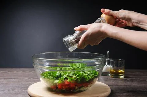 Adding pepper to salad Stock Photos
