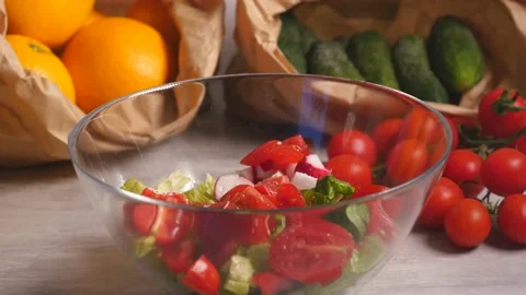 Adding pepper to vegetable salad of tomatoes, cucumber and lettuce Stock Footage 143394777