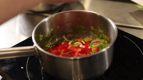 Adding peppers, Stainless pan, Stovetop cooking Stock-Footage 276187241