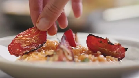 Adding piece baked tomato on a tomato risotto. Stock Footage 159399602