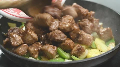 Adding pieces of meat to the vegetables and pineapple. 스톡 동영상 169800496