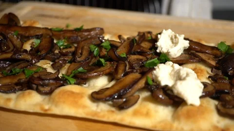 Adding pile of cream on top of mushroom flatbread pizza, slow motion Stock Footage 124398573