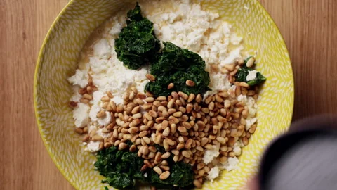 Adding Pine Nuts To Spinach Feta Bowl Top View Видео 337246892
