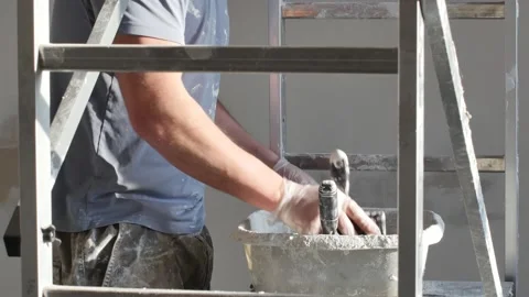 Adding the plaster powder to the water in a mixing container by sprinkling or Stock Footage 147514325