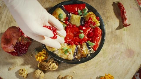 Adding pomegranate to eggplants and pepper with walnuts Stock Footage 138127692
