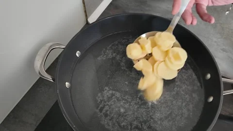 Adding potato pieces to water for boiling 스톡 동영상 347018317