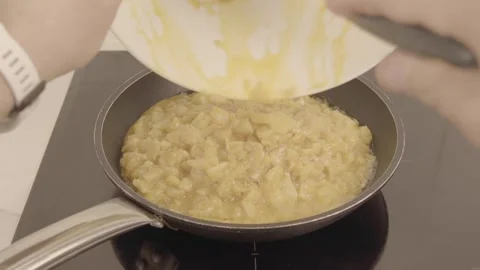 Adding potatoes and egg to the pan to make potato omelette 스톡 동영상 240463598