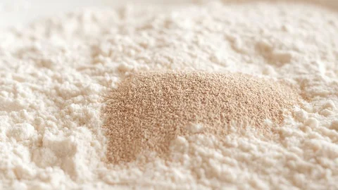 Adding pouring dry instant yeast into flour Stock-Footage 127714596