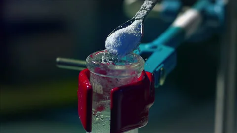 Adding a powder substance to a chemical experiment Stock Footage 257033071