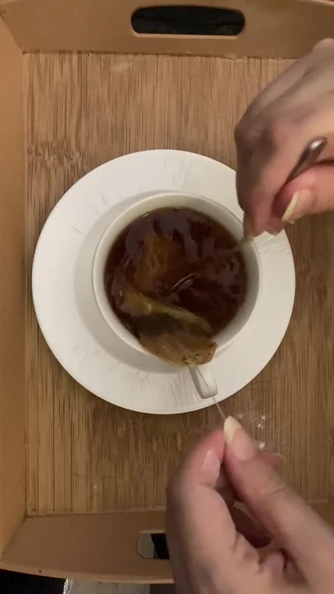 Adding a powdered milk to the tea. Stock Footage 283475535