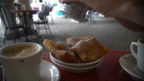 Adding powdered sugar to a beignet in New Orleans Stock Footage 86128367