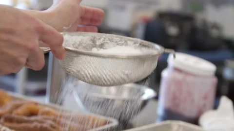 Adding powdered sugar into cooked donuts Stock Footage 307339994