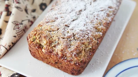 Adding powdered sugar to zucchini bread Stock Footage 92535981