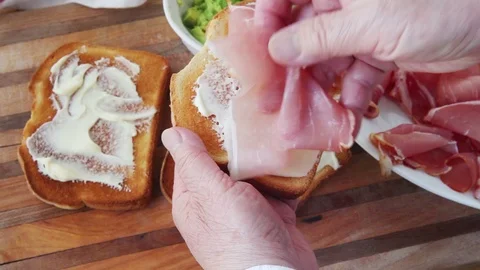 Adding prosciutto slices to toasted bread Stock Footage 98516843
