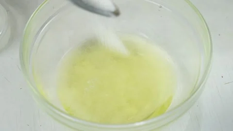 Adding putting sugar to egg white in glass bowl cooking food on kitchen. Stock Footage 313127304