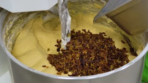 Adding Raisins to Dough in Industrial Dough Mixer. Pouring Dried Raisins into Stockbeeldmateriaal 333979859