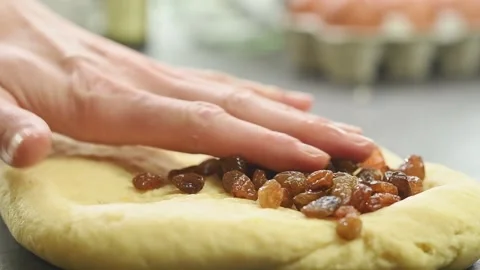 Adding raisins to the dough. Process of preparing Easter bread muffin. Stock Footage 165466433
