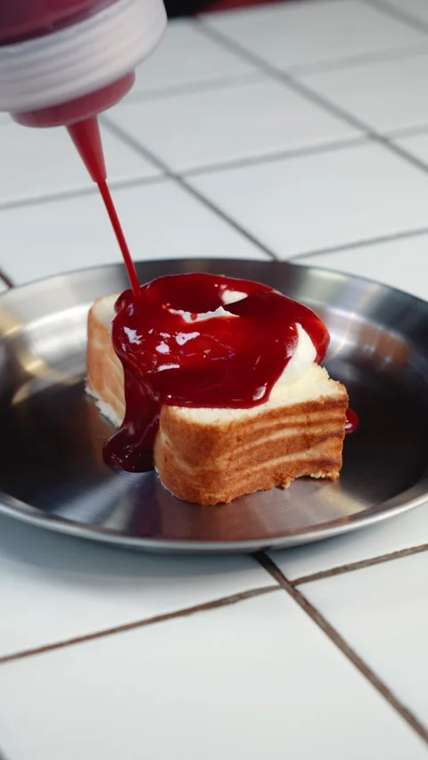 Adding Raspberry Sauce to Cheesecake Slice Stock Footage 342924329