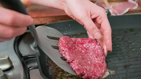 Adding a raw beefsteak into a grilling pan in 4K. Stock Footage 153752495