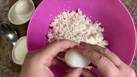 Adding raw chicken eggs to cottage cheese to make cottage cheese dough. Stock-Footage 301324013