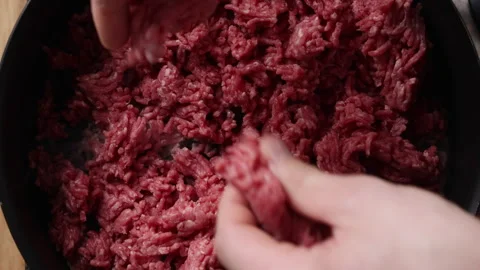 Adding Raw Ground Beef to Frying Pan Top View Close Up Vídeos de archivo 336569908