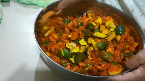 Adding Raw Mango to Homemade Pickle Spice Mixture and Mixing Ingredients Video stock 337775376