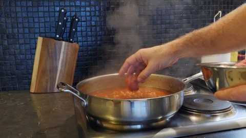 Adding raw meatballs to saucepan for cooking in italian tomato sauce Stock Footage 111926398