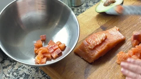 Adding raw salmon cubes into bowl for poke preparation Stock-Footage 333263127