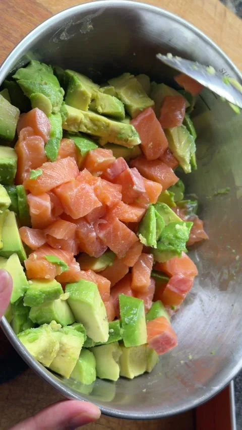 Adding raw salmon cubes into bowl for poke preparation 스톡 동영상 333263130