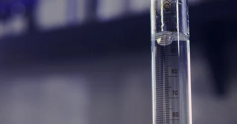 Adding a reagent to a glass vial in a lab Stock Footage 76618469