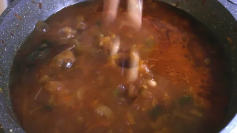Adding red and white beans into hot boiling rustic vegetable soup Stock Footage 194517181