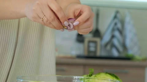 Adding red onion into a bowl with salad by removing them from slices. Healthy Stock Footage 144757214
