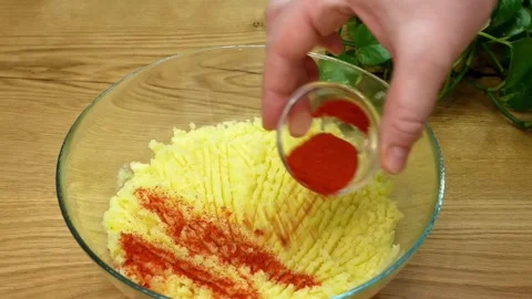 Adding red paprika salt and black pepper to mashed potatoes in a glass bowl Stock Footage 325071802